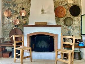 DieronaTraditional House with Mountain View - Dierona Village的客厅配有两把椅子和壁炉