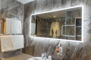 科尔切斯特Marks Tey Hotel Colchester的浴室配有盥洗盆、镜子和浴袍