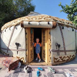 Kaji-SayAgat Yurt Camp的站在游戏帐篷门口的儿童