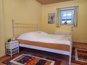 HornburgDas kleine Haus的卧室配有白色的床和窗户。