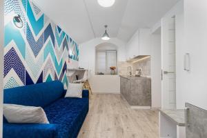 敖德萨Apart Hotel Lyon d'Opera的一间带蓝色沙发的客厅和一间厨房