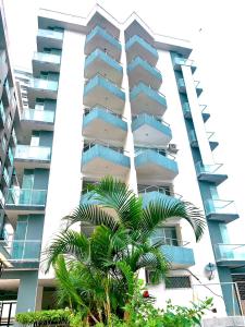 通苏帕Acogedor departamento junto al mar - Tonsupa的一座高大的建筑,前面有一棵棕榈树