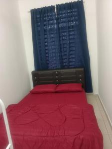 瓜拉立卑Afna Homestay 2的一间卧室配有一张带红色床单的床和一扇窗户。