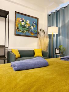 曼谷Cozy chic Silom townhouse studio 2-4的一间卧室配有黄色的床和沙发
