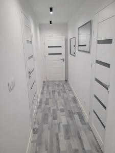瓦多维采Apartament NIKOLA的走廊设有两扇白色门,铺有瓷砖地板