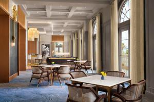 那不勒斯The Ritz-Carlton Naples的用餐室设有桌椅和窗户。