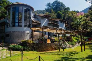 彼得罗波利斯Quinta da Torre 7 suítes Cachoeira SPA aquecido的房屋前方设有吊床
