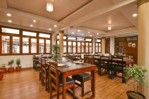 西隆HOTEL INDIANA的餐厅设有木桌、椅子和窗户。