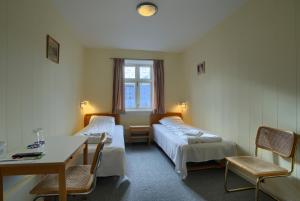 马里博厄布斯本斯酒店的一间设有两张床和一张桌子及椅子的房间