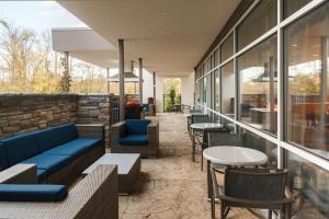 萨默塞特萨默塞特富兰克林小镇斯春季山丘套房酒店的餐厅设有蓝色的沙发、桌子和窗户。