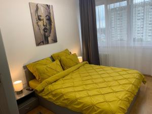 布拉索夫Victoriei Boulevard Private Apartment的卧室内的一张黄色床罩
