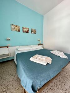 卡托利卡Hotel Sylva的蓝色客房,配有带毛巾的床