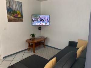 帕皮提Fare Manatea 19的客厅配有沙发和墙上的电视