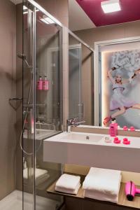 施韦夏特慕奇夕维也纳机场酒店的带淋浴、盥洗盆和镜子的浴室
