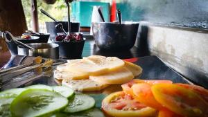 PelawattaSingharaja Garden AGRO ECO Lodge的托盘,盘子上放奶酪片,西红柿和黄瓜片