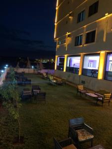 DargeçitZ&A kılıç apart otel的一座建筑,在晚上前面有一堆长椅