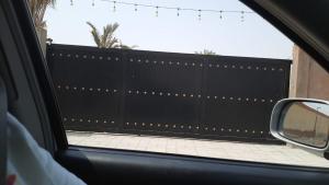 Al ḨamrānīyahDesert Breeze Farm Resort的从车窗可欣赏到黑色围栏的景色