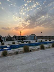 Al ḨamrānīyahDesert Breeze Farm Resort的一个带围栏和大楼的停车场