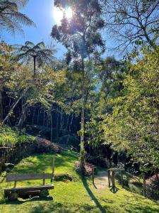彼得罗波利斯Quinta da Torre 7 suítes Cachoeira SPA aquecido的草地上木凳的公园