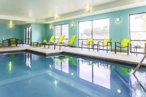 奥斯汀SpringHill Suites by Marriott Austin Parmer/Tech Ridge的一座游泳池,里面设有黄色的椅子和桌子