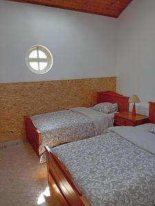 AlmosterRetiro d'Azenha的一间卧室设有两张床和窗户。