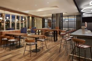卡尔加里卡尔加里机场万怡酒店的一间带木桌和凳子的餐厅