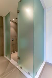 浦那Centro的浴室内带镜子的玻璃淋浴间门
