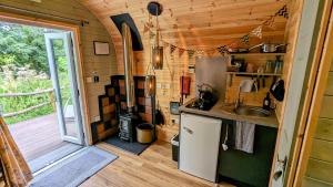 霍利韦尔Emlyn's Coppice - Luxury Woodland Glamping的一间带水槽和炉灶的小厨房
