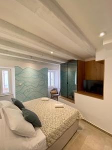 维斯House Malena - Rooms的一间卧室设有一张床,墙上配有电视。