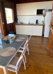波尔兰特Bungalows Lanar'am Kaladja -1的厨房配有桌椅和冰箱。