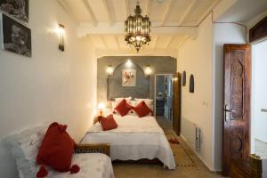 索维拉莱德阿耶索维拉酒店的一间卧室配有两张带红色枕头和吊灯的床。