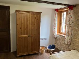 CornacLa Grange Du Noyer的一间卧室配有木制橱柜和一张床