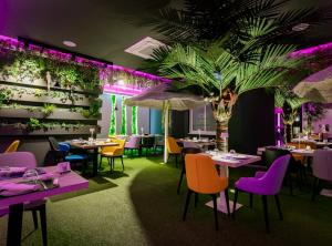 梵蒂冈角卡拉布里亚拉布索拉酒店的一间设有桌椅的餐厅,并种植了棕榈树