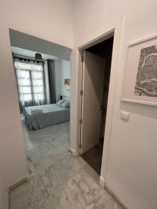 塞维利亚斑点中央旅馆的一间卧室配有一张床,一扇门通往房间