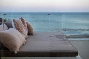依拉佩特拉Porto Lygia Apartment的一张带枕头的床,享有海景