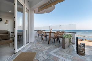 依拉佩特拉Porto Lygia Apartment的一间带桌椅和海洋的客厅