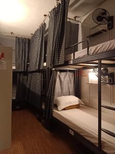 峇六拜Cozy AC Shared Bunk Beds in Bayan Lepas的一间卧室配有两张双层床和窗帘