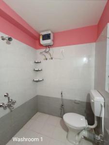 桑蒂尼盖登Bolpur Shantiniketan Bungalow on Kopai River的一间带卫生间的浴室和墙上的电视
