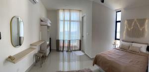 哥打京那巴鲁The Seashore House, The Shore Kota Kinabalu的一间卧室配有床、镜子和水槽