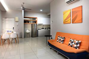 马六甲InStay Atlantis - The Orange的一间带橙色沙发的客厅和一间厨房