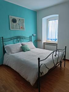 Guardando le Mainarde的一间卧室配有一张蓝色墙壁的床和一扇窗户
