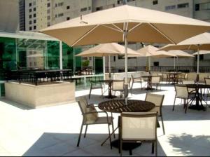 圣保罗上方酒店的一个带桌椅和遮阳伞的户外庭院。