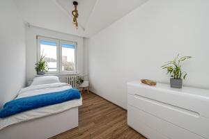 索波特Apartament Octopus Sopot Kamienny Potok的白色的卧室设有床和窗户