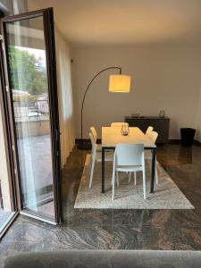 巴韦诺Casa Parisi Lago Maggiore的餐桌、白色椅子和玻璃门