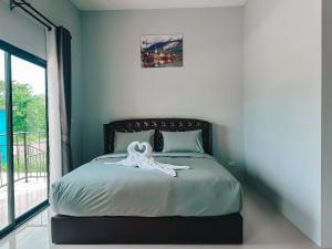 武里南Tuscany Hotel Buriram的一间卧室配有一张白色长袍的床