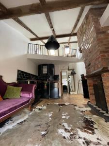 达宁顿堡Egos的客厅配有紫色沙发和砖砌壁炉