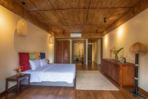 和平HỒ ĐÁ CỔ THIÊN LONG Hoa Le的卧室设有白色的床和木制天花板。
