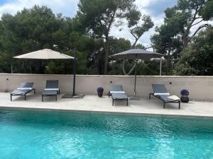 罗维尼Villa Salteria 3, pool, private territory, pinery的一组椅子和遮阳伞,位于游泳池旁