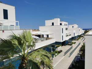 弗拉门卡海滩Turquesa del Mar - Max Beach Golf - Large Sunny Terrace Apartment的享有棕榈树白色建筑一侧的景致