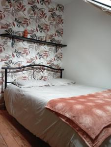 GuempsL'essentiel的一间卧室配有一张带花卉壁纸的床